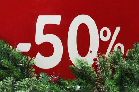 Winter sale 50 percent.Red background with fir branches. -50%  discount. Winter sale. Christmas...