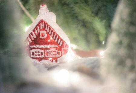 Beautiful Christmas house with fir paws on blurred backgroundの写真素材