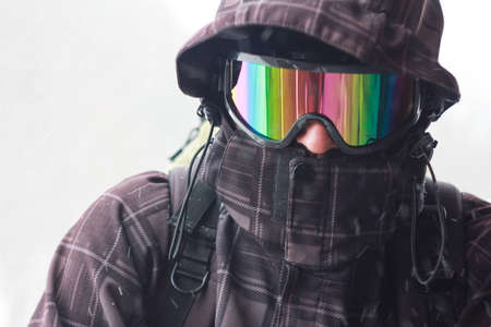 Portrait of a tourist with a backpack in bad weather in the mountains. Heavy snowstorm. Face closed...