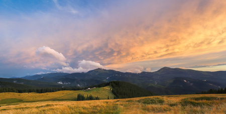 Traditional alpine house and mountain pastures at sunset in summer. Panoramic view on Mountain...