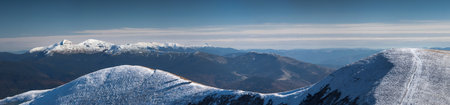 Winter mountains, panorama - snow-capped peaks of the Alps. Panoramic landscape with beautiful snow covered summits in sunny day. Aerial view of high peaksの写真素材