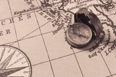 Magnetic old compass on world vintage map.Travel, geography, navigation, tourism and exploration concept background.Macro shot, shallow focus.の写真素材