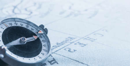 Magnetic old compass on world vintage map.Travel, geography, navigation, tourism and exploration concept background.Macro shot, shallow focus.の写真素材