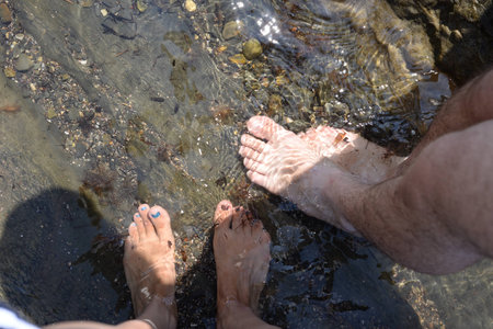 Male and female feet in sea water