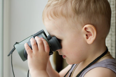 The boy looks through binocularsの写真素材