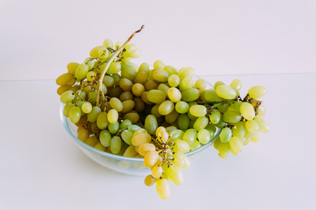 Fresh green grapes in basket. Isolated on white