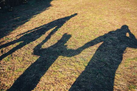 Family-mom, dad and me. Walking along a country road in hot summer.の写真素材