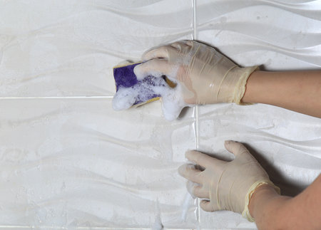 Female hands in latex gloves close-up wash with a foam spongeの写真素材