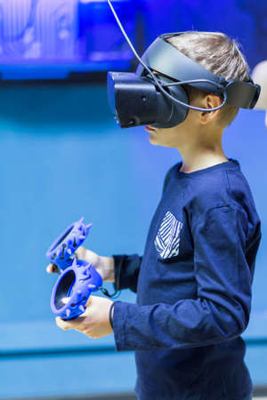 boy in virtual reality glasses playing on the background of the monitor