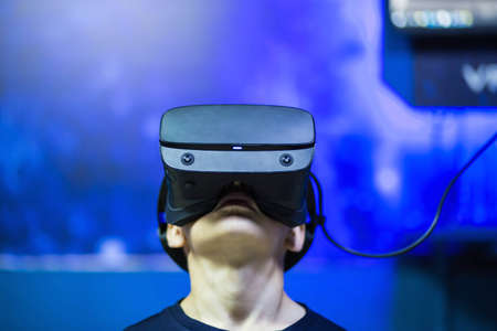 boy in virtual reality glasses playing on the background of the monitor