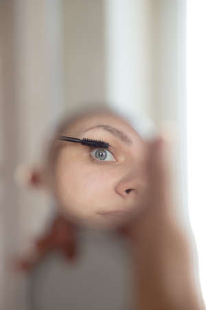 Young woman looking at her reflection in the mirror. High quality photoの写真素材