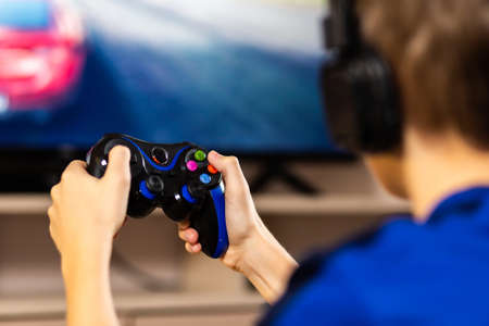 Young gamer playing online video games while streaming on social media. Blurred background and...