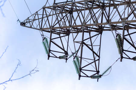 High voltage power lines on cloudy sky background