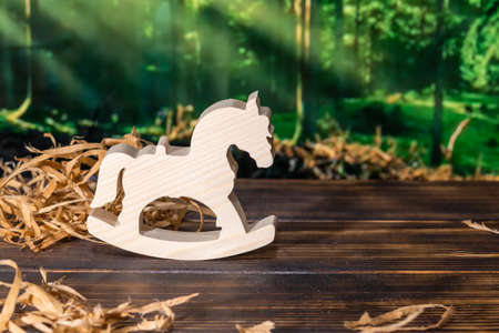 Wooden puzzle in the form of a handmade horse on the background of the forestの写真素材
