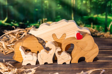 Wooden puzzle in the form of a family of handmade elephants on the background of the forestの写真素材