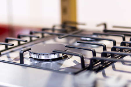 Gas stove burner close-up on a blurred background.