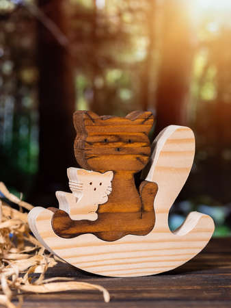 Wooden puzzle in the form of a handmade cat family on the background of the forest.の写真素材