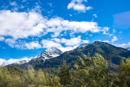 Beautiful view of green mountains shrouded in white clouds in Sochi.