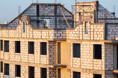 Multi-storey unfinished house without a roof at a construction site.