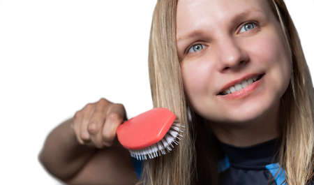 Blurred woman combing wet hair with massage comb on white backgroundの写真素材