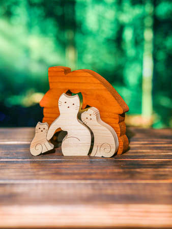 Wooden puzzle in the form of a handmade cat with a heart on the background of the forestの写真素材