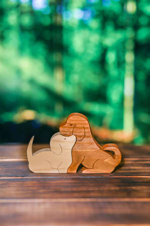 Wooden puzzle in the form of a family of handmade dogs on the background of the forestの写真素材