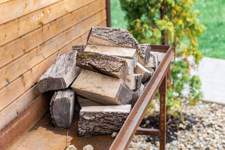 Close-up firewood on a wooden background is neatly stacked in the barbecue area.