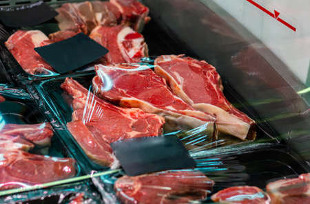 Raw chilled vacuum-packed pork steaks on a shop window.の写真素材