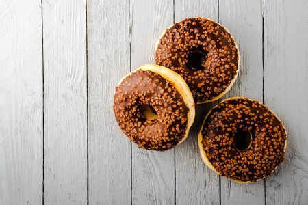 Donuts with chocolate on white wooden background, top view.の写真素材