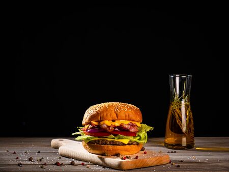 Bacon burger with beef patty on wooden tableの写真素材