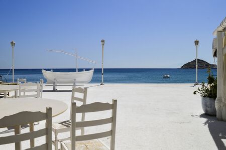 Boat with sea and blue sky background in a calm and secluded beach on the Greek island of Mykonosの写真素材