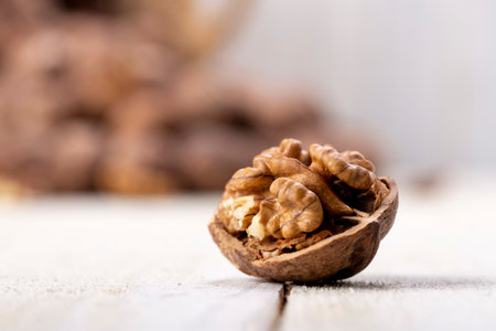 Close-up wonderful details of walnut kernel and stacked walnuts on bokeh background
