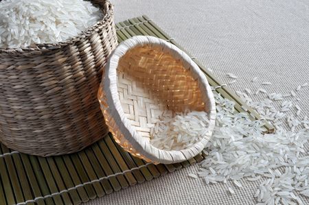 Rice contained in small baskets sitting on a bamboo mat.の写真素材