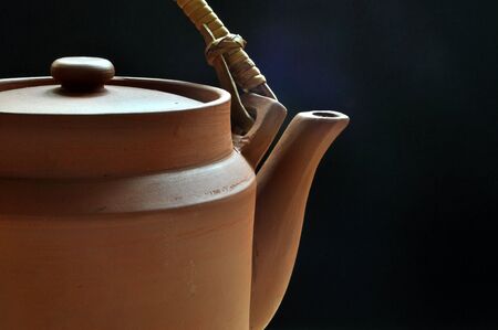 A simple and traditional Chinese clay teapot in front of an uneven blue background.の写真素材