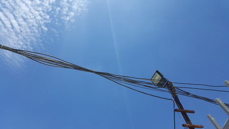 black binded wire and spot light with blue sky background on sunny dayの写真素材