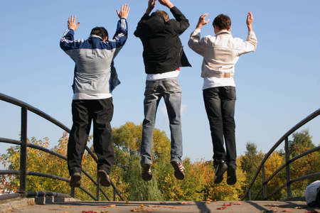 jump boys on autumn bridgeの写真素材
