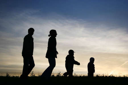 walking family of four on skyの写真素材