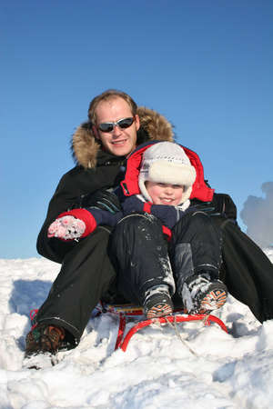 winter father with child on sled