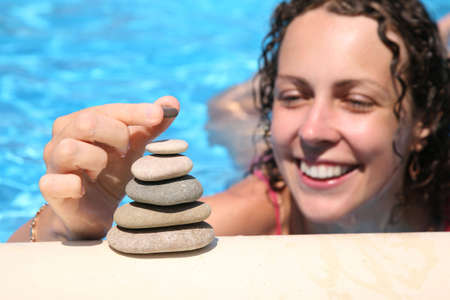 The woman builds a figure of stones about water