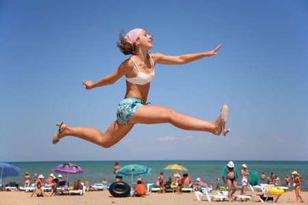 The woman jumps on a beach.の写真素材