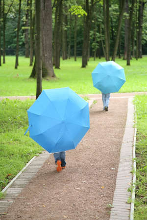 two children under the umbrellas in the parkの写真素材