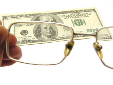 one hundred dollars by the closeup through the eyeglasses on white backgound