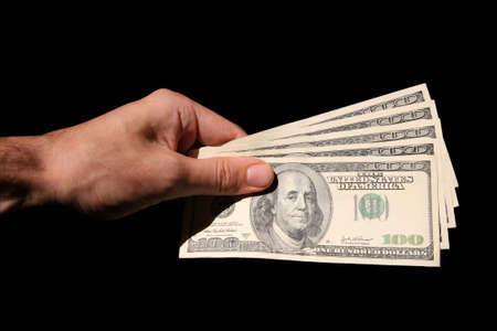 hand and dollars isolated on black backgrounds
