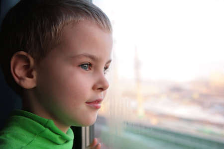 little boy looks in train`s window