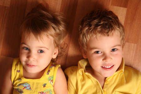two children lie on the floor