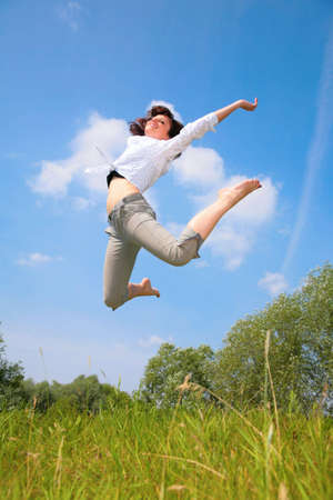 beauty woman jumps on grassの写真素材