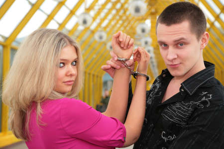 young man and blonde in handcuffの写真素材
