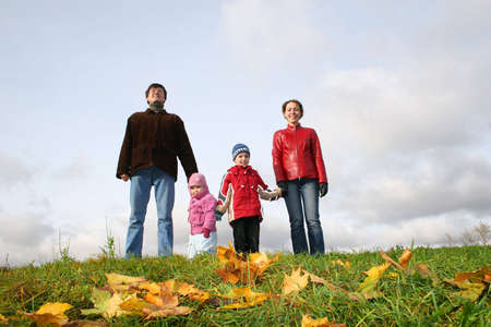 parents with children stand on meadow at autumnの写真素材