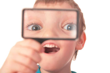 boy looks through  magnifier with surpriseの写真素材