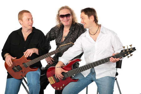 Three sitting men with two guitars. Talking music group.